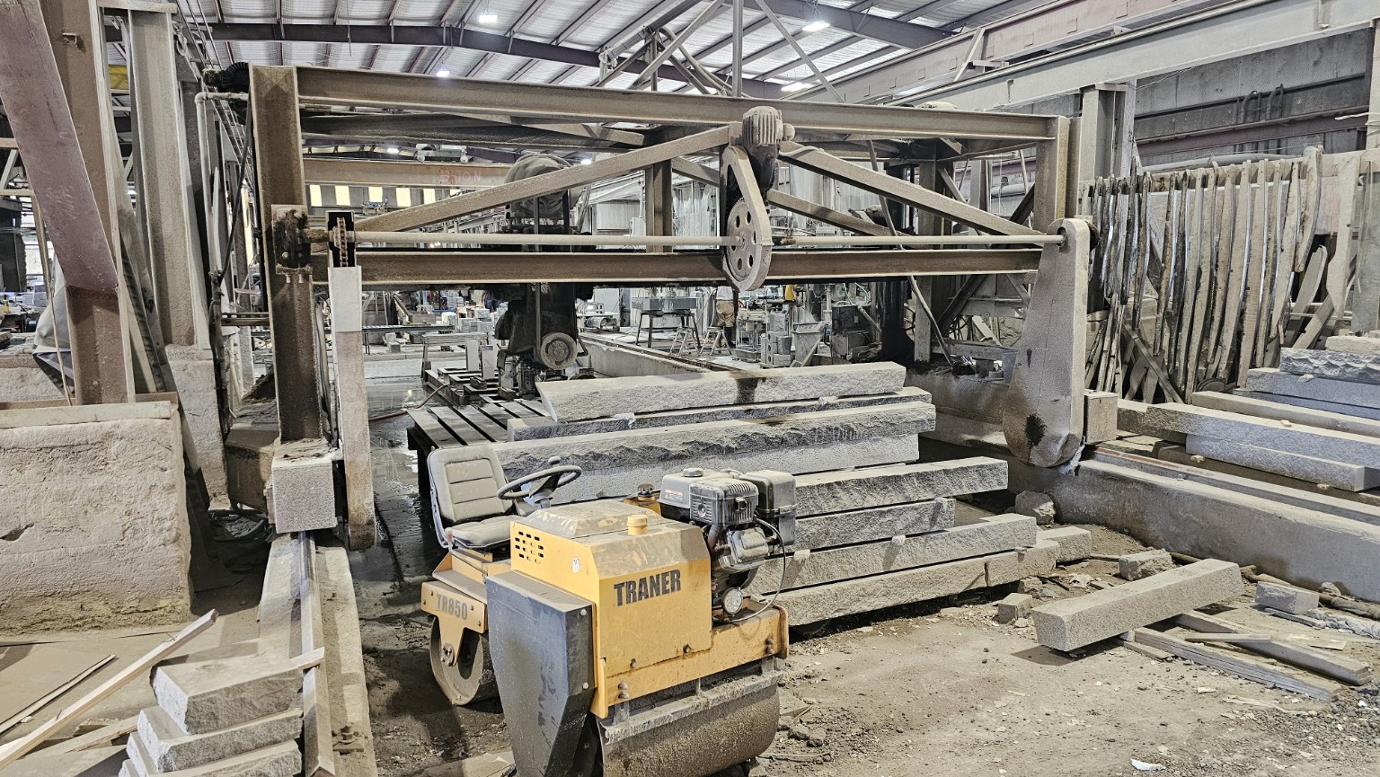 Stone-processing machinery and granite pieces inside the manufacturing partner’s factory